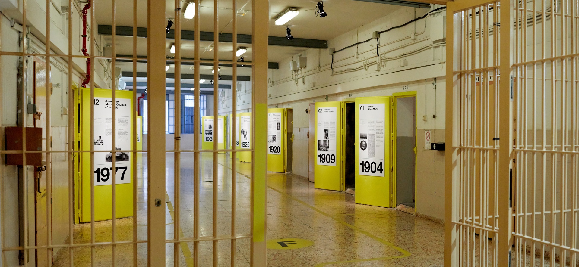 Visita museizada a la Presó Model. Galería 5, rejas de acceso y puertas amarillas.